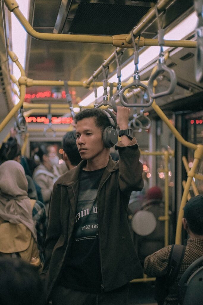 A young man listens to music on a crowded TransJakarta bus, Jakarta, Indonesia.
